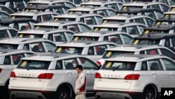 A worker walks past Haval SUV models parked outside the Great Wall Motors assembly plant in Baoding in north China's Hebei province, Feb. 19, 2017.