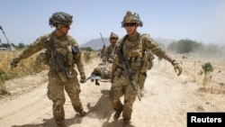FILE - U.S. Army soldiers carry Sgt. Matt Krumwiede, who was wounded by an improvised explosive device (IED), towards a Blackhawk Medevac helicopter in southern Afghanistan.