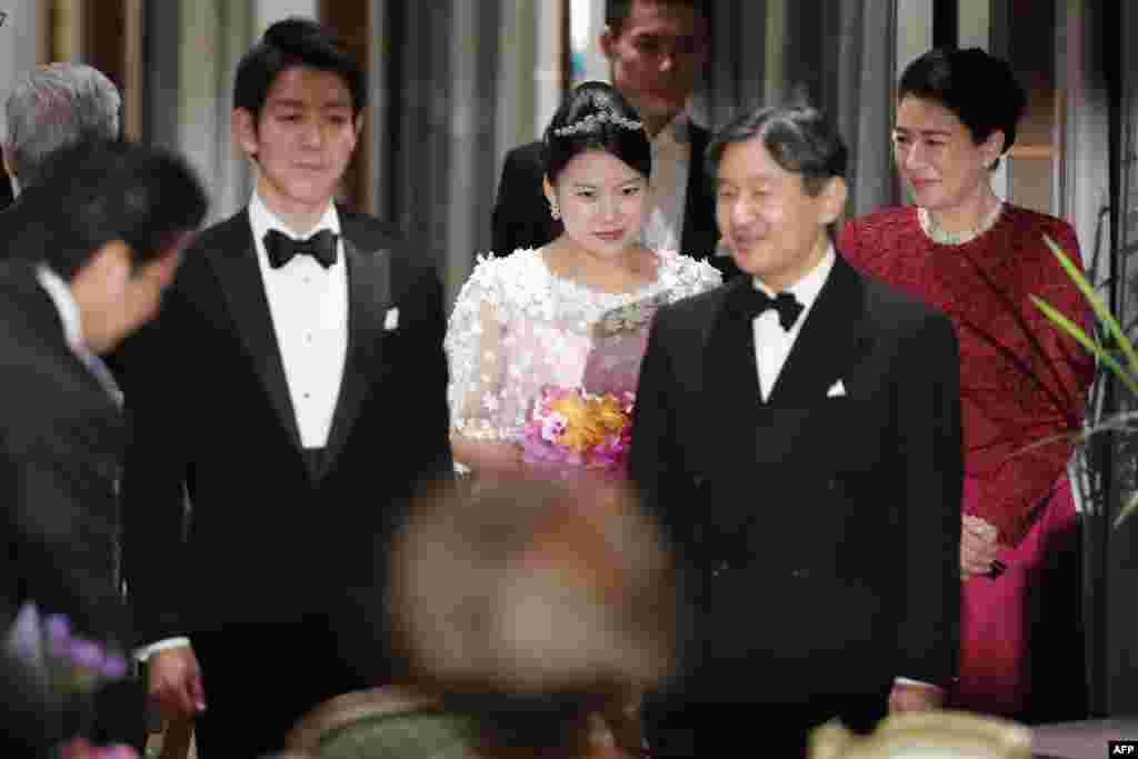 Japan&#39;s former princess Ayako Moriya (C) and her husband Kei Moriya (2nd L) arrive at their wedding banquet in Tokyo, with Crown Prince Naruhito (2nd R) and Crown Princess Masako (R) as Prime Minister Shinzo Abe bows.