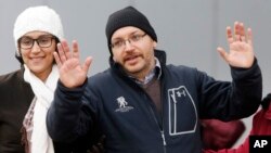 FILE - U.S. journalist Jason Rezaian gestures next to his wife, Yeganeh Salehi, in front of Landstuhl Regional Medical Center in Landstuhl, Germany, Jan. 20, 2016. Rezaian was released from an Iranian prison Jan. 17, 2016.