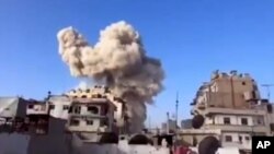 This image taken from video obtained from the Ugarit News shows smoke after a building was struck in a warplane attack in Homs, Syria, November 28, 2012.