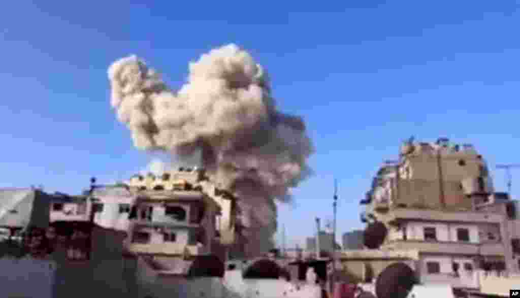 乌加里特新闻(Ugarit News)的视频图像显示，叙利亚霍姆斯的一栋建筑物2012年11月28日遭到一架战斗机袭击之后冒出浓烟。
