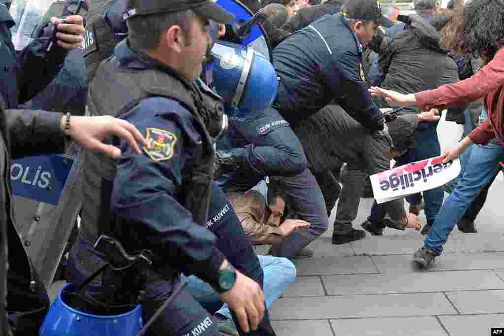 Demonstrators fall onto the ground as Turkish policemen (L) disperse a protest of pro-secular Turks outside the Parliament in Ankara.