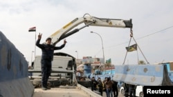Iraqi security forces lift concrete blockades in order to remove checkpoints in Iraq's capital of Baghdad, Dec. 20, 2016. 