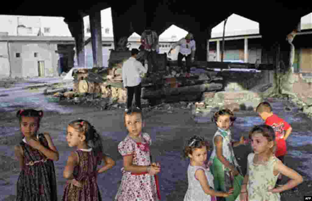 Children seen in front of a destroyed tank at the vegetable market near Tripoli street in Misrata, Libya, Friday, Sept. 2, 2011. (AP Photo/Sergey Ponomarev)
