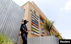 A security guard stands outside the Westgate shopping mall that has been left deserted following last year's attack by al-Shabab gunmen in Nairobi that killed at least 67 people, Sept. 18, 2014.