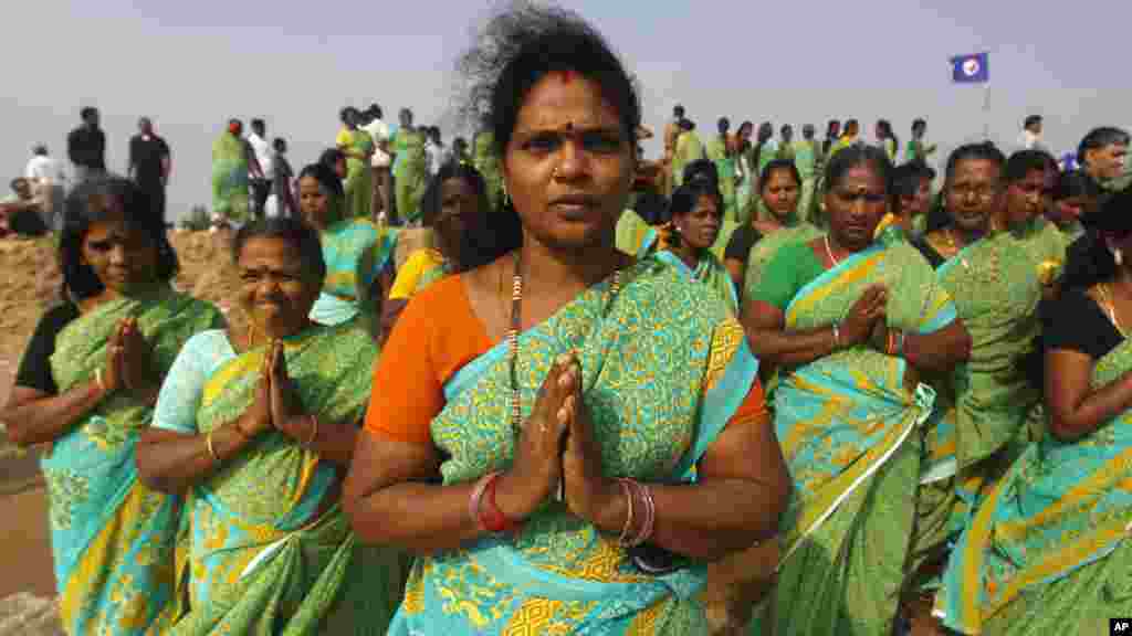 Des femmes indiennes prient sur la plage Marina dans la baie du Bengale pour commémorer le 10ème anniversaire du tsunami de 2004 à Chennai, en Inde, vendredi 26 décembre 2014.