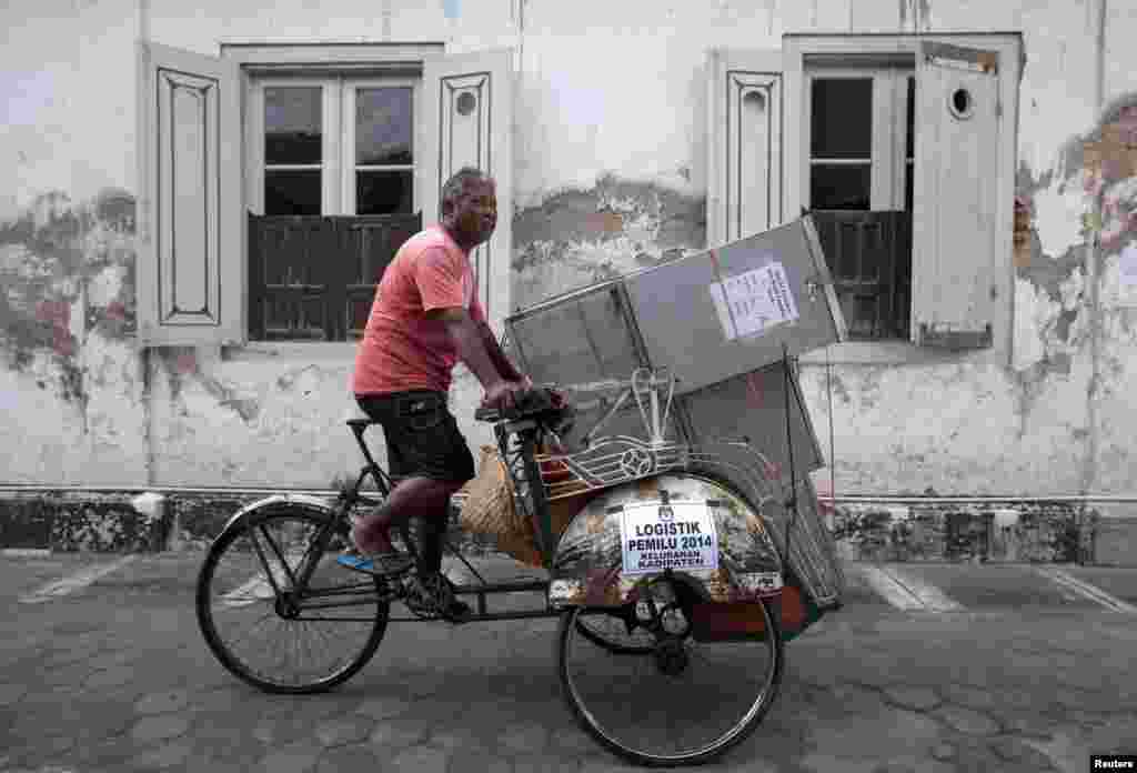 Tukang becak membawa kotak-kotak berisi kertas suara untuk TPS-TPS di Yogyakarta (8/7).&nbsp;(Reuters/Dwi Oblo)