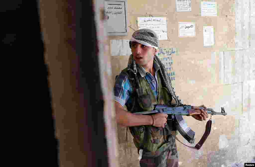 A Syrian rebel fighter stands guard in Saif al-Dawla district of Aleppo city, August 22, 2012. 