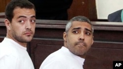 FILE - Al-Jazeera English producer Baher Mohamed, left, and Canadian-Egyptian acting Cairo bureau chief Mohammed Fahmy appear in court during their trial on terror charges, in Cairo, Egypt. 