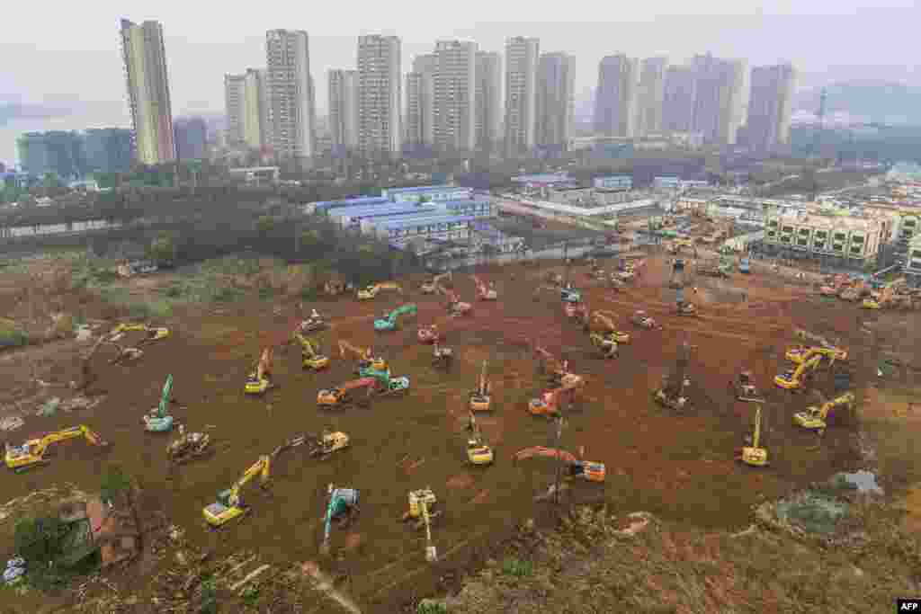 Excavators work at the construction site of a new hospital being built in a staggering 10 days to treat patients from a virus outbreak in Wuhan in China&#39;s central Hubei province.