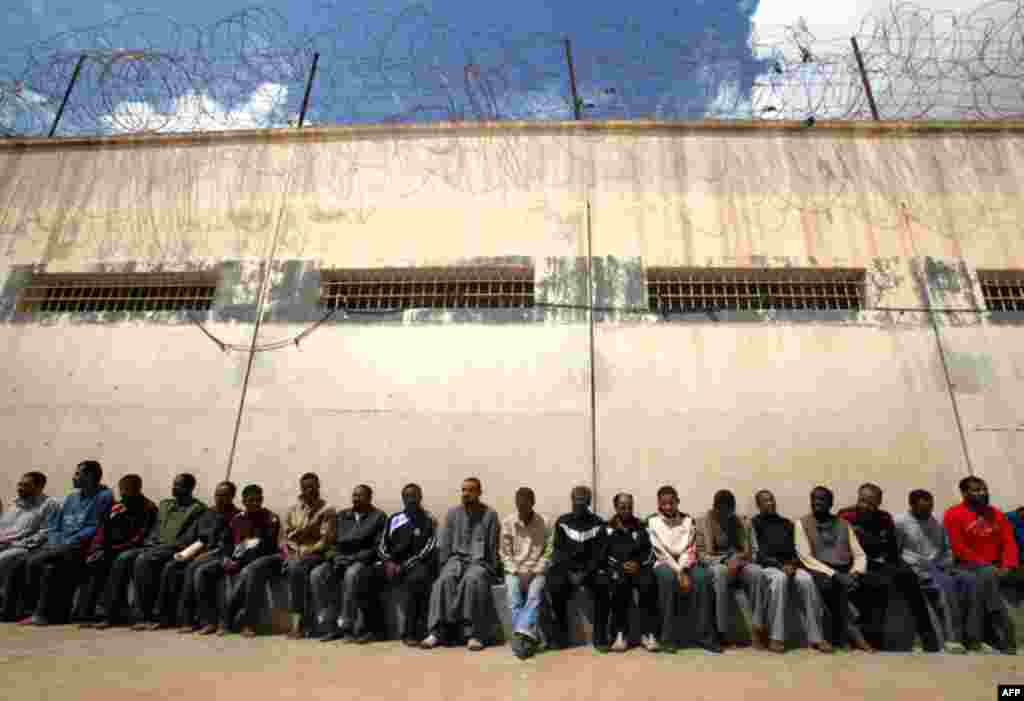 March 24: Mercenaries and forces loyal to Libyan leader Muammar Gaddafi sit inside a prison in Benghazi. (Reuters)