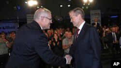 Australian Prime Minister Scott Morrison, left, and opposition leader Bill Shorten shake hands before the Sky News/Courier Mail People's Forum in Brisbane, May 3, 2019. (Gary Ramage/Pool via AP)