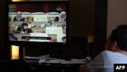 Reporters watch a live feed of Libyan members of parliament meeting to decide on a prime minister, May 4, 2014. 