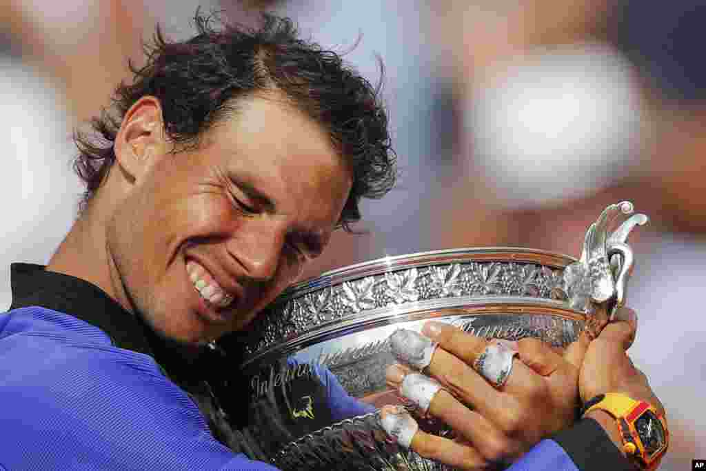 Spain&#39;s Rafael Nadal holds the trophy as he celebrates winning his tenth French Open title against Switzerland&#39;s Stan Wawrinka in three sets, 6-2, 6-3, 6-1, during their men&#39;s final match of the French Open tennis tournament at the Roland Garros stadium, in Paris, France.