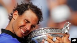 2017年6月11日，西班牙网球运动员拉菲尔•纳达尔怀抱奖杯，庆祝他第十次获得法网公开赛男单冠军。