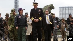 In this file photo, U.S. Adm. Samuel Locklear talks with Japanese Gen. Shigeru Iwasaki, front left, after inspecting Patriot missile units deployed in Tokyo, April 11, 2012.