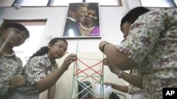 A portrait of U.S. President Barack Obama and his wife Michelle is seen hanging on the wall as students build a structure from straws during a class at an elementary school he once attended in Jakarta, Indonesia (Feb 2010 file photo)