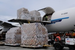 FILE - In this April 10, 2020, file photo, ground crew at the Los Angeles International airport unload pallets of supplies of medical personal protective equipment from a China Southern Cargo plane upon its arrival.