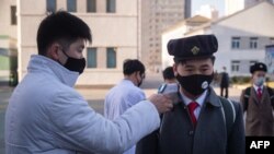 22일 북한 평양의학대학에서 신종 코로나바이러스 감염을 막기 위해 등교하는 학생들의 체온을 재고 있다.
