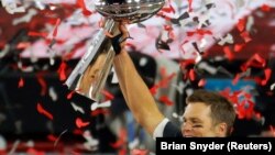 Tom Brady, pemain quarterback Tampa Bay Buccaneers, mengangkat piala Vince Lombardi setelah Buccaneers memenangkan laga final Super Bowl melawan Kansas City Chiefs, di Tampa, Florida, Minggu, 7 Februari 2021. (Foto: Reuters)