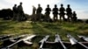 FILE - Weapons lie on the ground as Ukrainian personnel take a break during training at a military base with UK Armed Forces in Southern England on Oct. 12, 2022. 