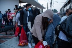 Guatemalans deported from the U.S., wearing masks as a precaution against the spread of the new coronavirus, board a bus after arriving at La Aurora airport in Guatemala City, May 4, 2020.