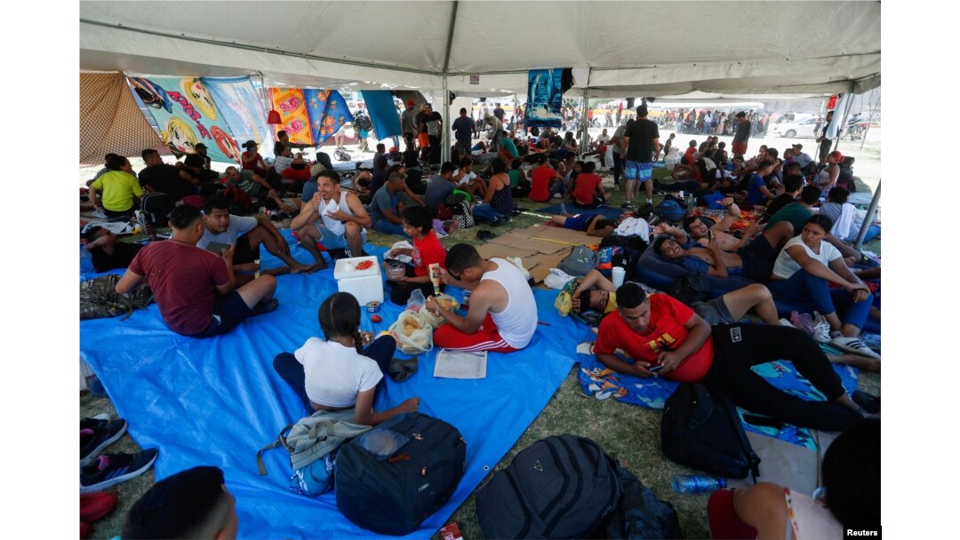 Solicitantes de asilo, en su mayoría de Venezuela, descansan a la sombra de una carpa instalada por las autoridades mexicanas cerca de la frontera mientras intentan cruzar a EEUU sin cita previa, en Nuevo Laredo, México, el 27 de junio de 2023. REUTERS/Daniel Becerril