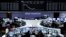 Traders are seen at their desks in front of the DAX board at the Frankfurt stock exchange, Germany, July 10, 2014. 