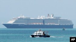 Sebuah perahu (speed boat), mengangkut sampel dari beberapa penumpang kapal pesiar "Westerdam" (latar belakang) yang dilaporkan sakit perut atau demam, saat berada di perairan dekat Sihanoukville, Kamboja, Kamis, 13 Februari 2020.