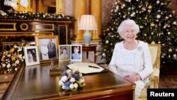 La reine Elizabeth sits à son bureau au Buckingham Palace, à Londres, le 24 décembre 2017. 