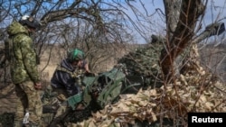 Ukrainian service members fire a 120 mm mortar toward Russian troops near the town of Bakhmut in the Donetsk region of Ukraine on March 8, 2024.