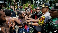 Papuan activists scuffle with police and soldiers during a rally near the presidential palace in Jakarta, Indonesia, Thursday, Aug. 22, 2019. 