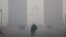 FILE - People take a selfie in front of the India Gate war memorial on a smoggy winter morning in New Delhi, India, Dec. 26, 2017.