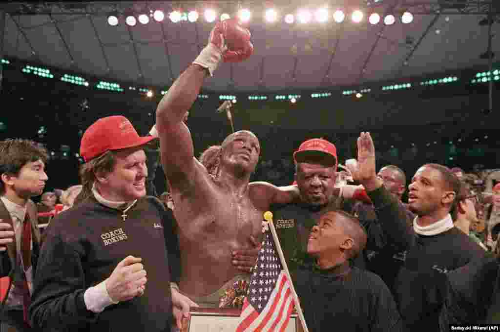 Heavyweight boxer James &quot;Buster&quot; Douglas waves his gloved hand to the cheering crowd as he makes his way to the dressing room following a 10th round knockout victory over Mike Tyson in 1990. It was one of the biggest boxing upsets ever.