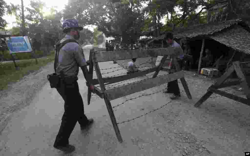 Polisi memasang barikade dan menjaga keamanan di Thandwe, negara bagian Rakhine, Burma. 