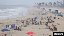 People relax at the ocean in Huntington Beach, California, July 23, 2020. 