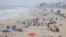People relax at the ocean in Huntington Beach, California, July 23, 2020. 