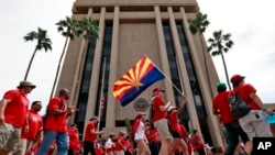 Teachers rally outside of Arizona Gov. Doug Ducey's Executive Tower in Phoenix on their third day of walkouts, April 30, 2018. 