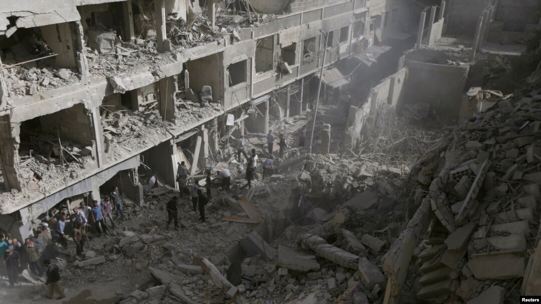Warga memeriksa sebuah lokasi yang hancur setelah serangan udara yang dilancarkan oleh pasukan setia Presiden Bashar al-Assad di Douma, sebelah timur al-Ghouta, dekat Damaskus (24/9).