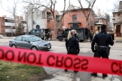 Law enforcement officers stand at the perimeter of a home in Boulder as part of their investigation into a shooting at King Soopers grocery store, before leaving after finding no connection to the incident, in Boulder, Colorado, March 22, 2021.