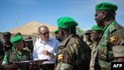 Wakil Sekjen PBB Jan Eliasson (kedua dari kiri) berbicara dengan staf medis dari Kontingen Uganda yang melayani Misi Uni Afrika di Somalia, Mogadishu (27/10). (PBB/Stuart Price).