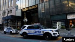 Des véhicules de la police new-yorkaise montent la garde devant la Trump Tower, résidence de l'ancien président américain à New York, le 27 mars 2023.