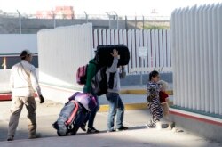 FILE - A family leaves to apply for asylum in the United States, at the border, Jan. 25, 2019, in Tijuana, Mexico.