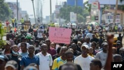 Manifestantes carregam cartazes durante manifestações contra o aumento de impostos, enquanto os deputados continuam a debater a Lei das Finanças de 2024, em Kisumu, no oeste do Quénia, a 20 de junho de 2024. (Fotografia de Brian ONGORO / AFP)