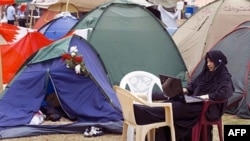 An anti-government Bahraini protester uses the Internet outside her tent in Manama's Pearl Square last year