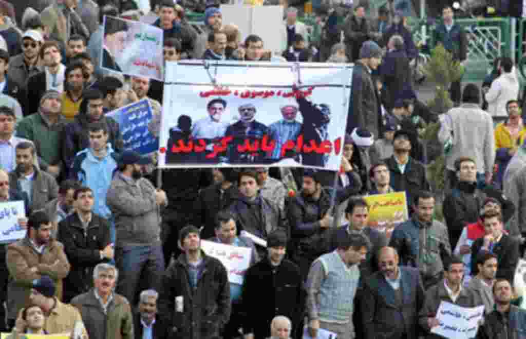 Iranian regime loyalists hold a poster with doctored pictures of former president Mohammad Khatami (L) and opposition leaders Mir Hossein Mousavi (C) and Mehdi Karroubi on the gallows during a pro-government demonstration in Tehran, February 18, 2011