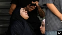 Relatives of the victims react near the site of Friday's Israeli strike in Beirut's southern suburbs, Sept. 21, 2024.