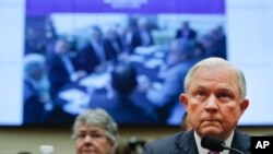 An image reading "National Security Meeting TRUMP Make America Great Again Washington, D.C, March 31 2016" is displayed behind Attorney General Jeff Sessions as he testifies during a House Judiciary Committee hearing on Capitol Hill, Tuesday, Nov. 14, 2017 in Washington.