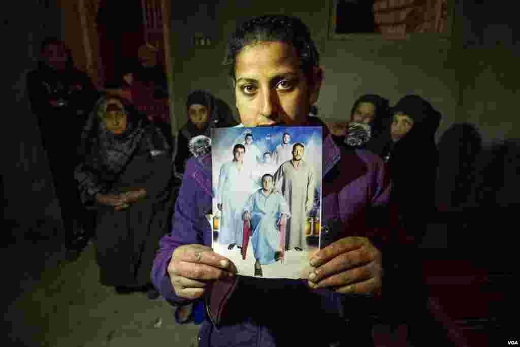 A woman named Magda holds up a portrait of her brother and two cousins, each kidnapped and later executed by Islamic State militants in Libya. Terror attacks increase against Copts in correlation with the new year holidays almost every year. (H. Elrasam/V